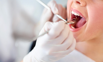 Child receiving dental examination with a dentist using tools for oral care at Oro Valley Dental Arts.