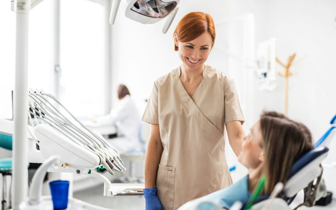 Dentist smiling at patient in dental office, highlighting patient care and comfort during treatment.