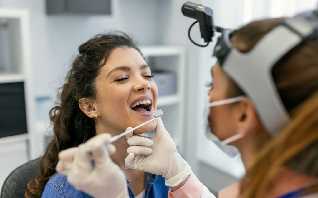 Patient receiving dental examination with hygienist using dental tools in modern clinic setting.