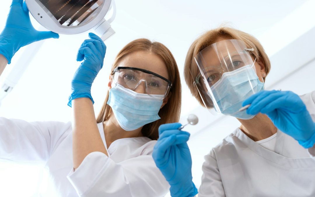 Dental professionals in PPE, examining dental tools and equipment, emphasizing dental care and implants.